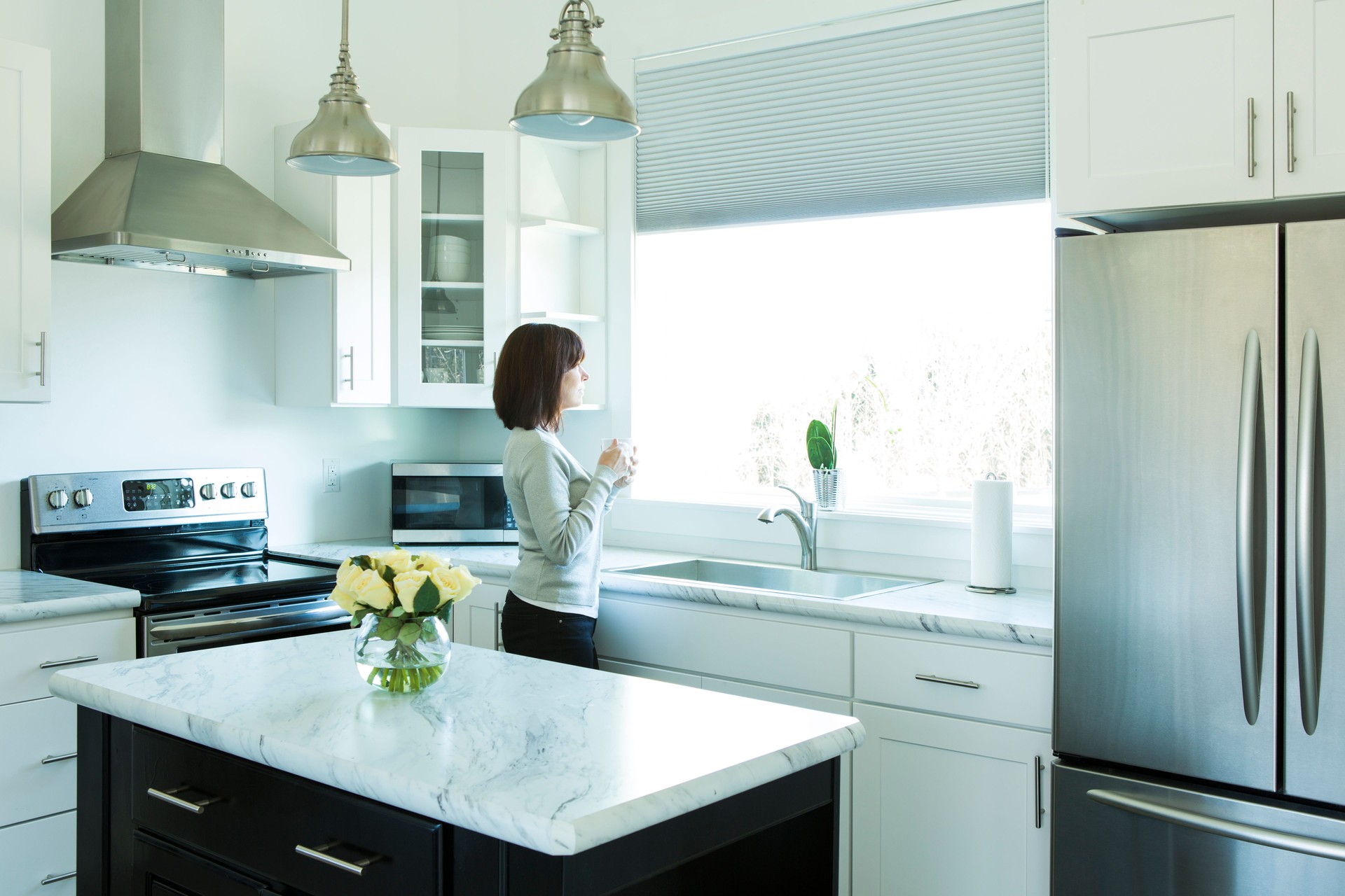 Woman Drinking Coffee in a Modern Kitchen